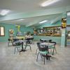 Ampia sala con tavoli e sedie, bancone bar e televisore in un angolo.