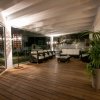 Veranda con sedie e piante, illuminata discretamente.