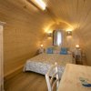 Interno di una camera con pareti in legno, letto matrimoniale.
