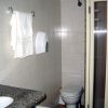 Bagno con bidet, wc, lavandino e doccia. Asciugamani appesi.