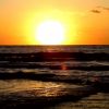 Sole al tramonto sopra il mare con onde leggere.