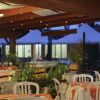 Ristorante esterno con tavoli apparecchiati di sera.