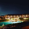 Vista notturna di una piscina e giardino illuminato.