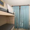 Camera con letto a castello, tenda blu e decorazioni sul tavolo.