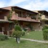 Edifici residenziali con giardino e vegetazione.