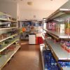 Corridoio di un alimentari con scaffali pieni di prodotti confezionati.